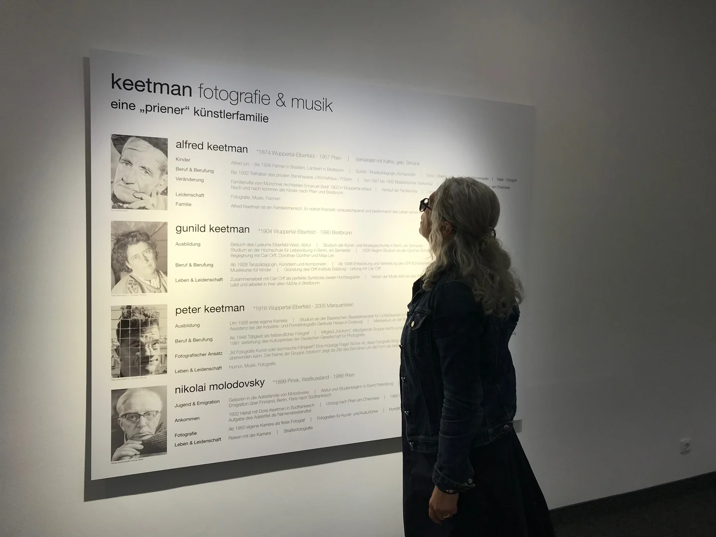 Eine Person betrachtet eine Ausstellungstafel zur Künstlerfamilie Keetman.
