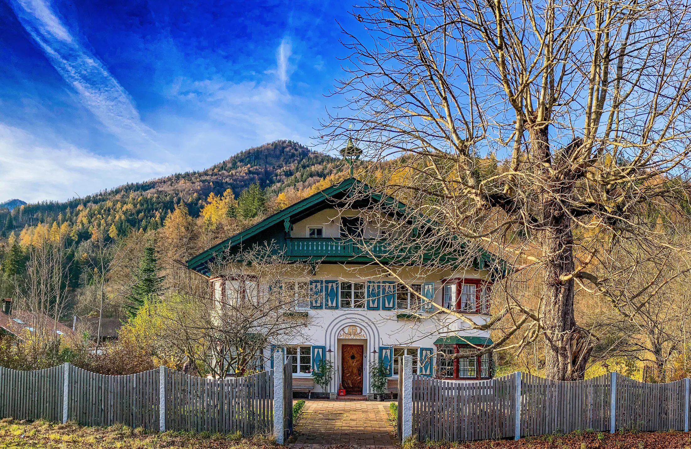 Historisches Landhaus von Franz Zell vor einer bewaldeten Berglandschaft