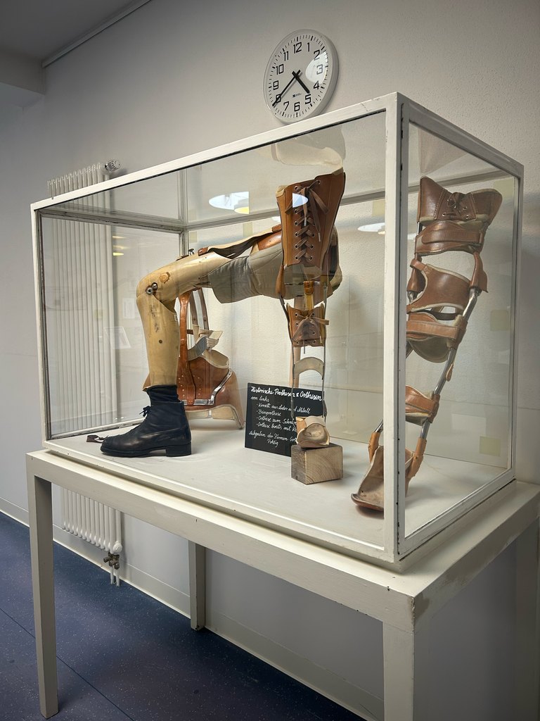 Historische Beinprothesen und Orthesen in einer Glasvitrine der Ausstellung in der Kinderklinik Aschau